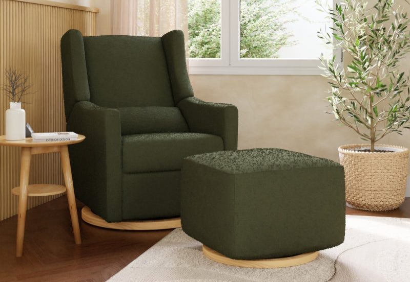A cozy, olive green nursery glider chair with a matching ottoman, set next to a small wooden table and a decorative potted plant in a sunlit room.