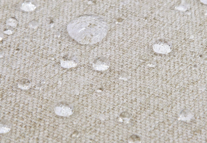 Close-up image of water droplets on a beige textile surface, demonstrating waterproof material.