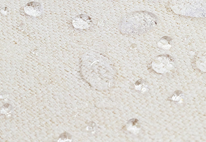 Close-up of a breathable, waterproof mattress with water droplets demonstrating its water-resistant surface.
