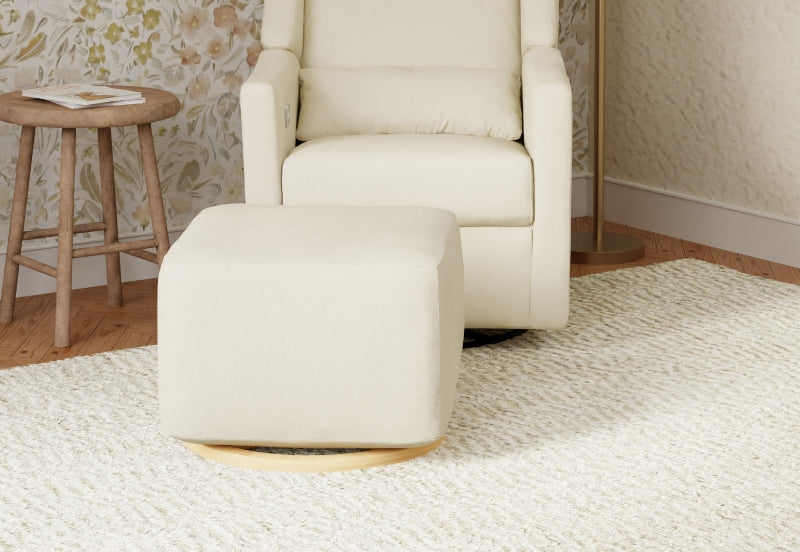 A cozy cream glider chair with a matching ottoman in a tastefully decorated nursery room.