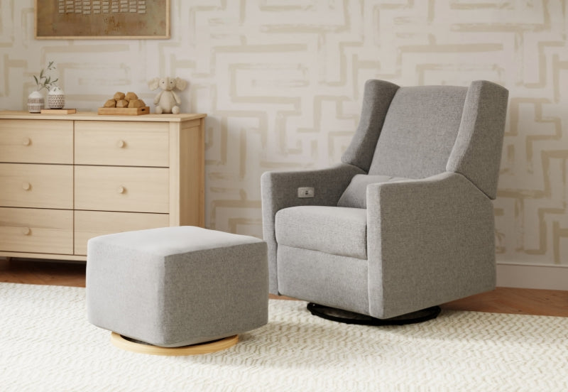 Modern gray nursery rocking chair and matching ottoman in a stylish room with neutral decor and a cream rug.