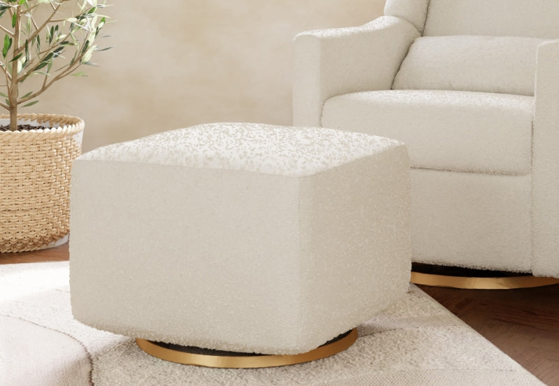 A modern white nursery glider and ottoman set in a cozy room corner with soft lighting and a potted plant.