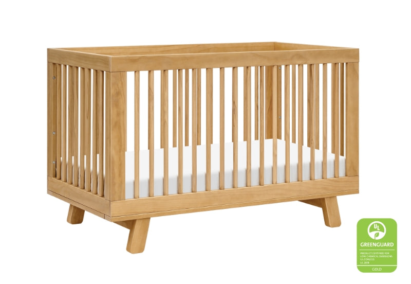 Modern wooden baby crib with a white mattress, certified by GreenGuard.
