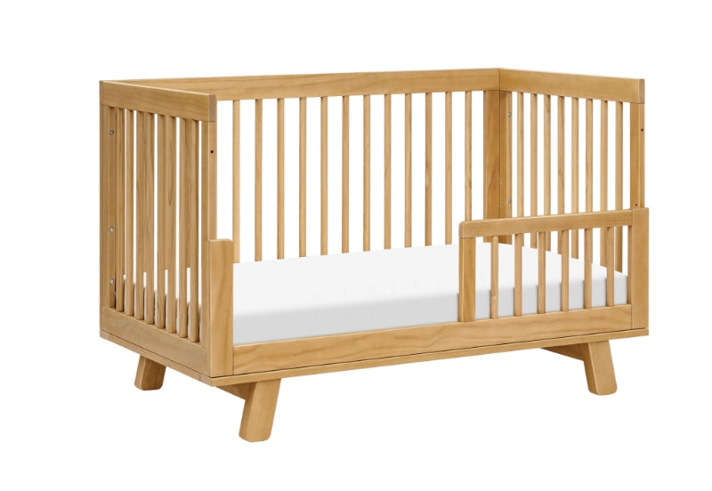 A modern wooden baby crib with a sleek design and sturdy build, isolated on a white background.