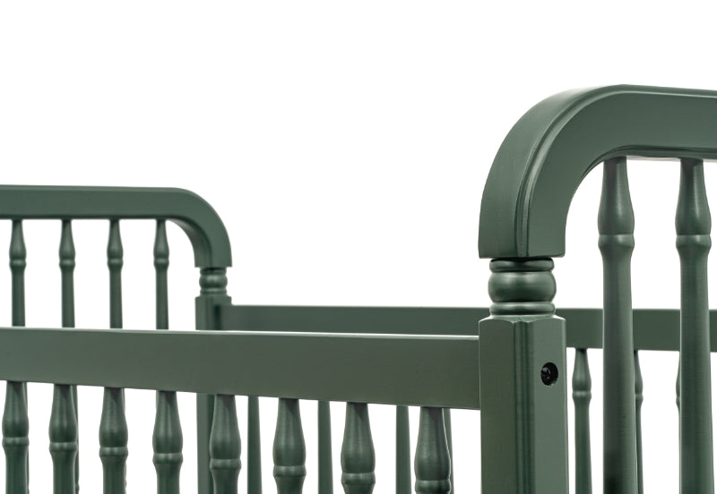 Classic green baby crib with traditional spindle design and curved headboard, isolated on a white background.