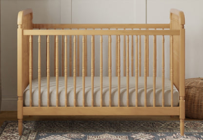 Wooden baby crib with a breathable mattress in a cozy room setting.