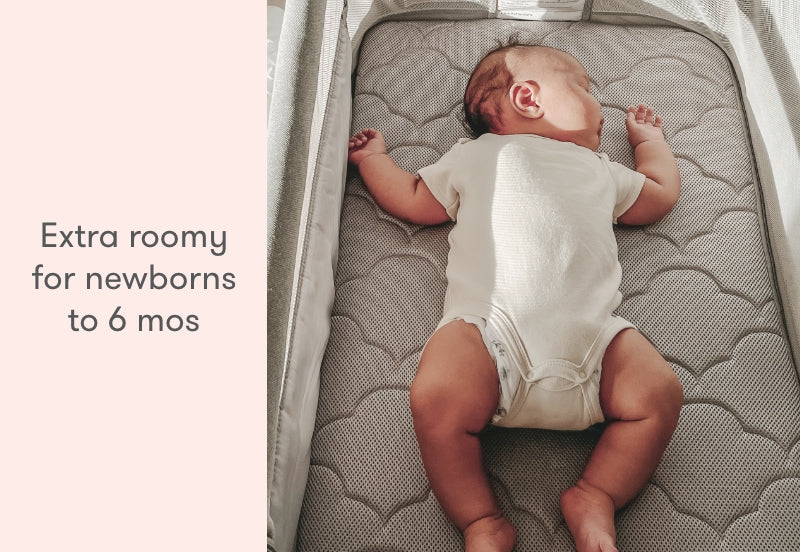 A newborn lies comfortably in a spacious crib mattress with a patterned cover, captioned "Extra roomy for newborns to 6 mos."