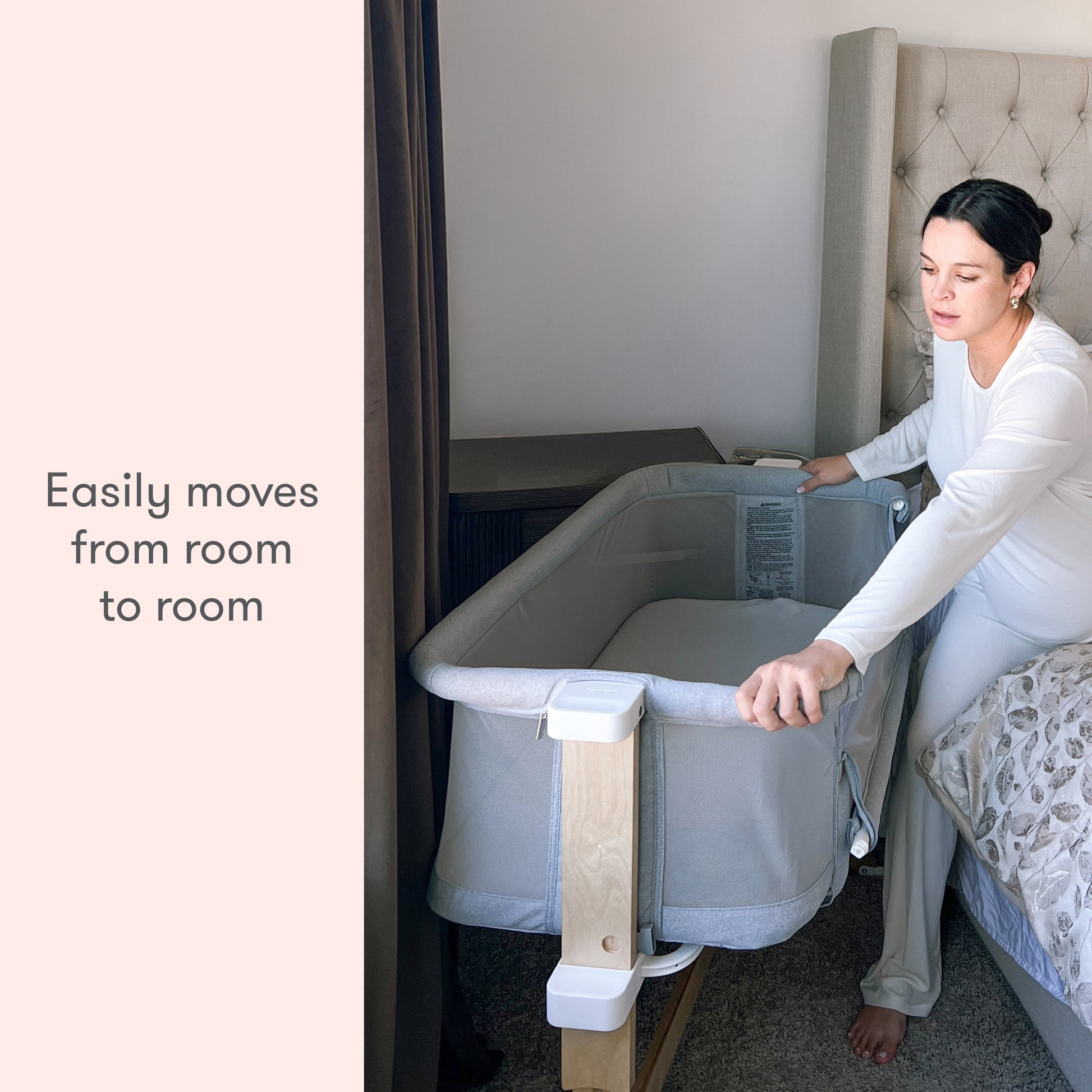 A woman smiling while demonstrating a portable baby bassinet with the caption "Easily moves from room to room."
