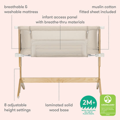 The Newton Baby Bassinet & Bedside Sleeper in beige and wood features mesh sides, a washable Wovenaire mattress, muslin cotton sheet, 8 adjustable heights, infant access panel, laminated wood base, and is Greenguard Gold certified.