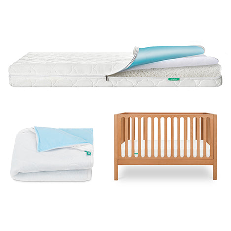 The Newton Baby Galileo Crib, Waterproof Mattress & Pad Set features a wooden crib, waterproof mattress and pad, plus a folded blue and white blanket—all essentials for your nursery, displayed on a white background.