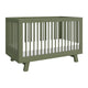 The Babyletto Hudson Convertible Crib features a modern olive green design with slatted sides, angled legs, and a white mattress—ideal for transitioning from crib to toddler bed as your child grows.