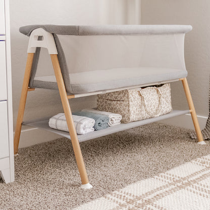 essential bassinet in nursery, storage space below cradle filled with baby care essentials 999-8402-GRY