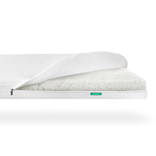 Newton Baby Essential Crib Mattress with a partially opened cover, revealing a white, breathable crib mattress core.