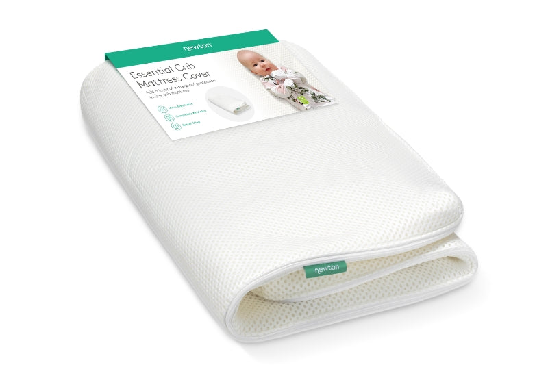 Newton Essential Crib Mattress Cover displayed with packaging featuring a smiling baby, highlighting its breathable and washable design.