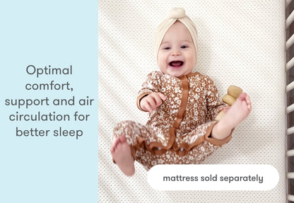 Happy baby wearing a floral outfit and headband lies on a mattress, with text emphasizing 'Optimal comfort, support and air circulation for better sleep - mattress sold separately.'