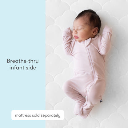 A sleeping infant in a pink onesie rests on a white Newton Baby Extra Waterproof Crib Mattress Cover. Text on a light blue background reads “Breathe-thru infant side” and “cover sold separately,” highlighting breathability.