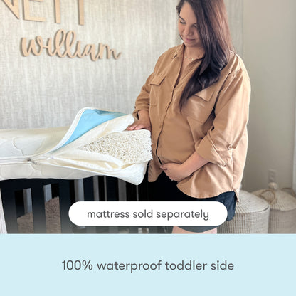A woman stands beside a crib, unzipping the Newton Baby Extra Waterproof Crib Mattress Cover to show its interior. Overlay text notes "Mattress sold separately" and "100% waterproof toddler side." Neutral-toned décor is in the background.