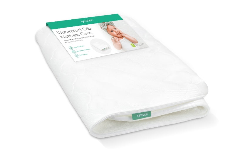 A Newton Baby waterproof crib mattress cover packaged neatly, featuring a tag with an image of a baby and text "Waterproof Crib Mattress Cover."