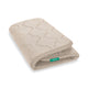 The Newton Baby Extra Bassinet Mattress Cover is beige and rectangular with a quilted wave pattern and a green 