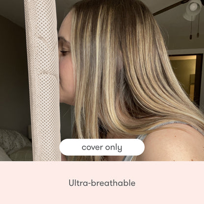 A woman presses her face against a Newton Baby Extra Bassinet Mattress Cover, highlighting its ultra-breathable, quilted fabric. "Cover Only" and "Ultra-breathable" appear on-screen, with a bed and ceiling fan in the background.