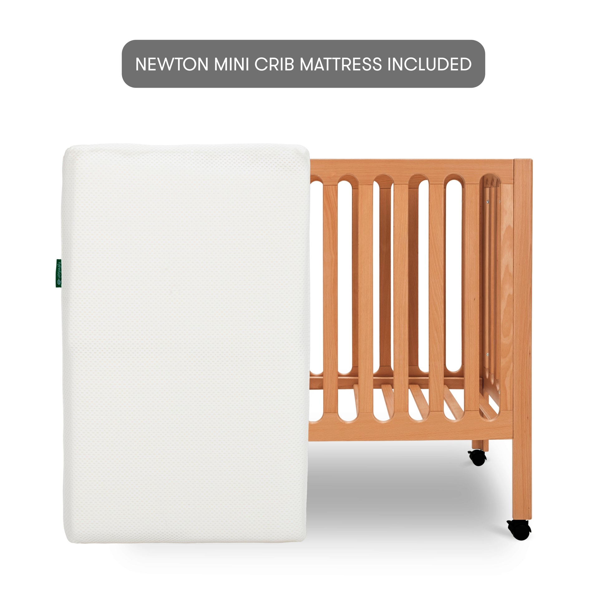 The Newton Galileo Mini Crib with wheels is shown with a white Newton Baby Mini Crib Mattress. A label above reads, "Newton Mini Crib Mattress Included.