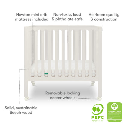 The Newton Galileo Mini Crib with Newton Mattress by Newton Baby is a white beech wood crib with locking caster wheels, non-toxic materials, heirloom quality, and PEFC and GREENGUARD certifications for safe, stylish portability.