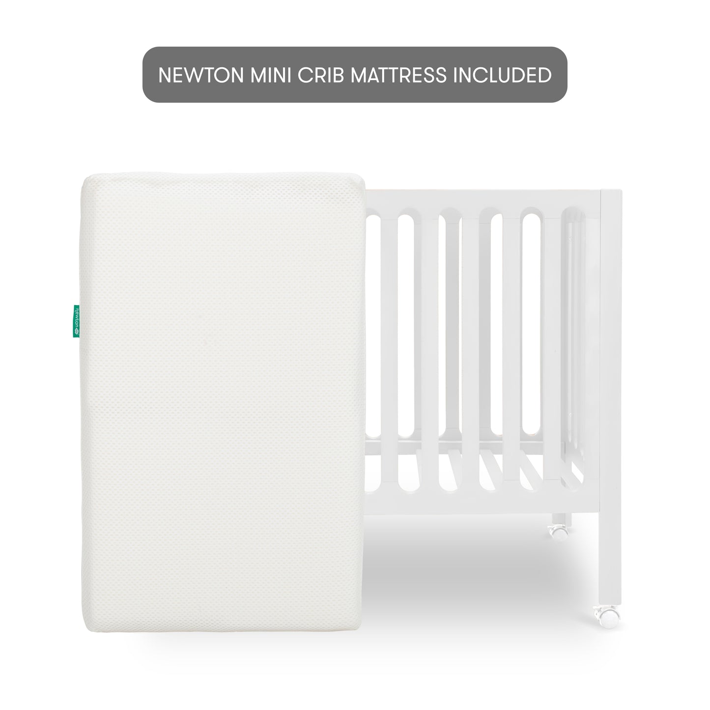 The Newton Galileo Mini Crib with Newton Mattress by Newton Baby features a white crib with vertical slats and wheels, shown behind a white mini crib mattress. A grey label above states: NEWTON MINI CRIB MATTRESS INCLUDED.
