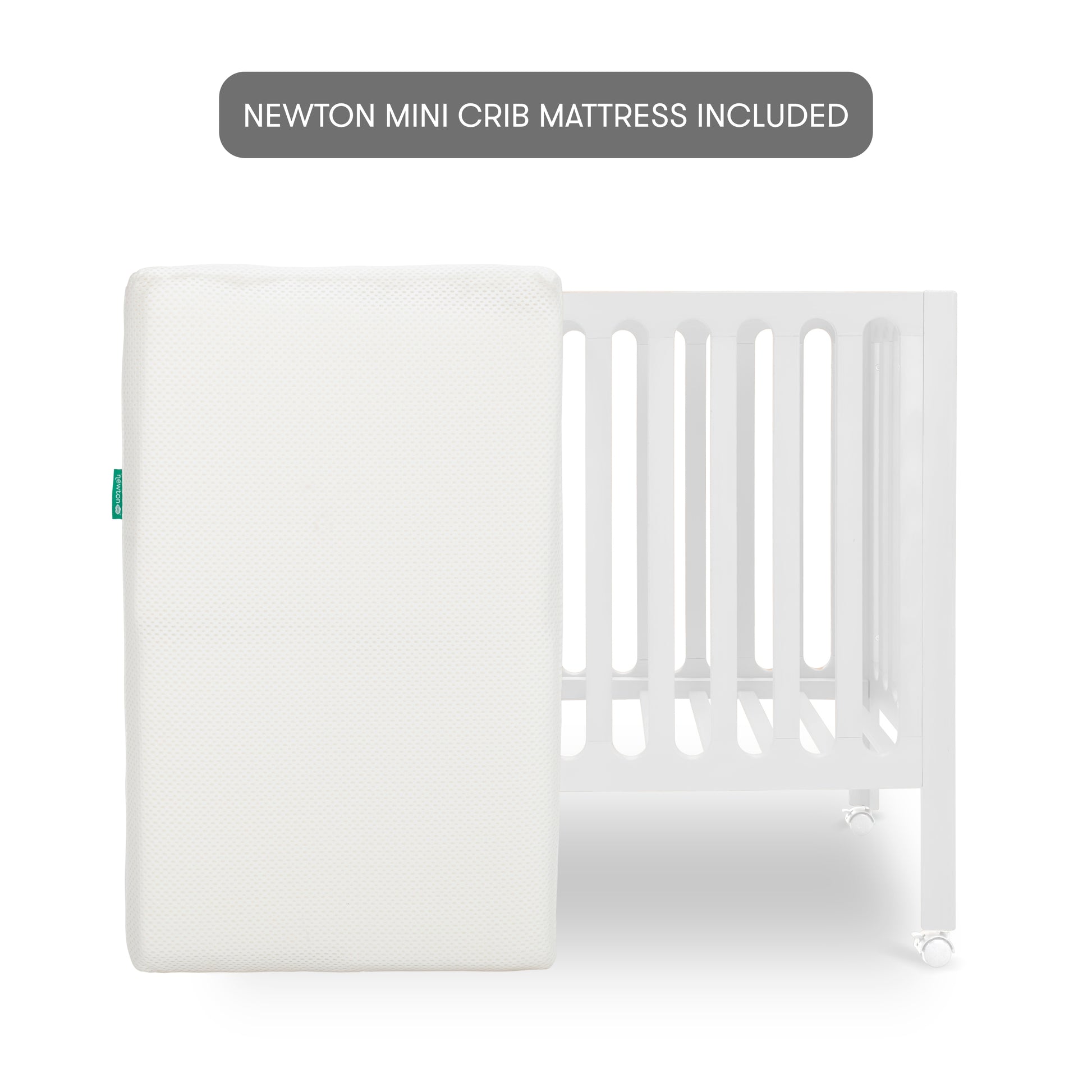 The Newton Galileo Mini Crib with Newton Mattress by Newton Baby features a white crib with vertical slats and wheels, shown behind a white mini crib mattress. A grey label above states: NEWTON MINI CRIB MATTRESS INCLUDED.