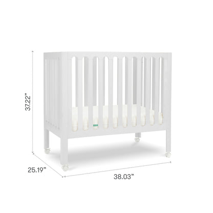 The Newton Galileo Mini Crib with Newton Mattress by Newton Baby is a portable beech wood crib with vertical slats, four caster wheels, and a mattress. Dimensions: 37.22" H x 25.19" D x 38.03" W; shown against a plain white background.