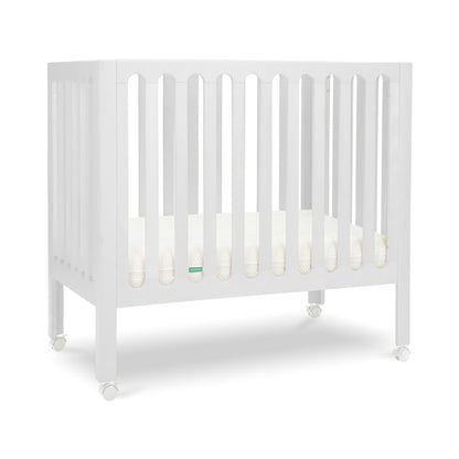 White modern crib on wheels with visible mattress, isolated on a plain background. 999-8430-WHT