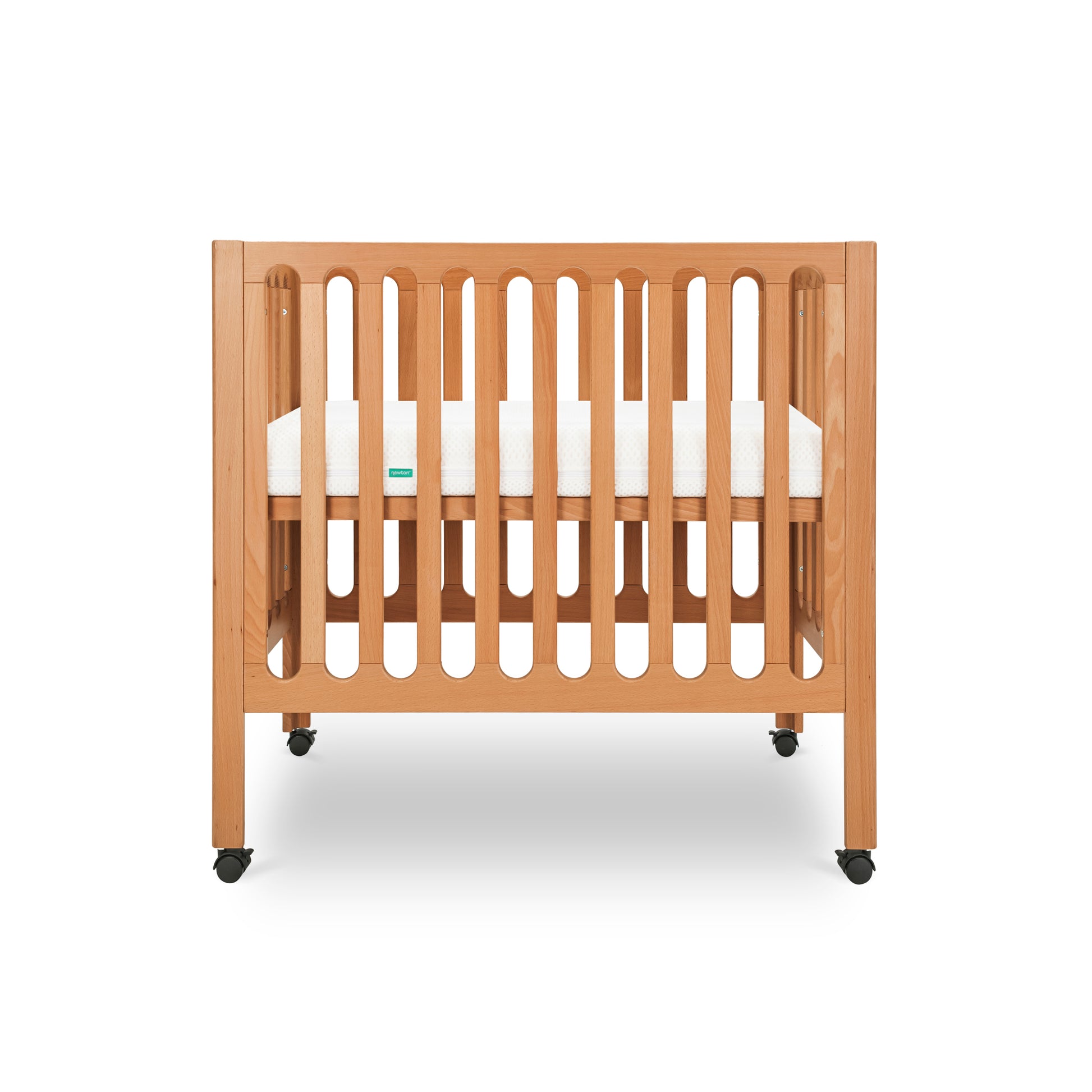 Modern wooden crib on wheels with visible mattress, isolated on a white background. 