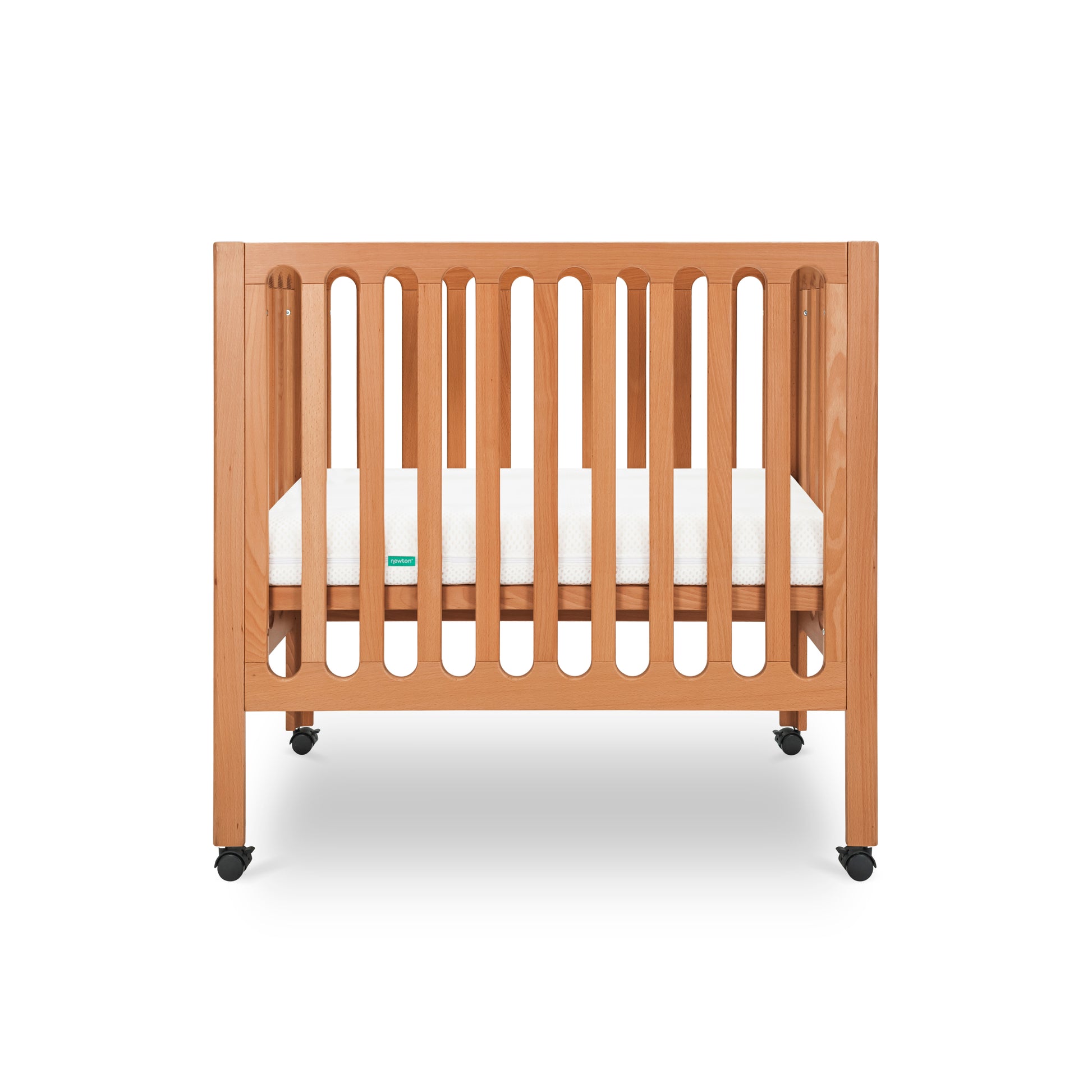 Modern wooden crib on wheels with visible mattress, isolated on a white background. 