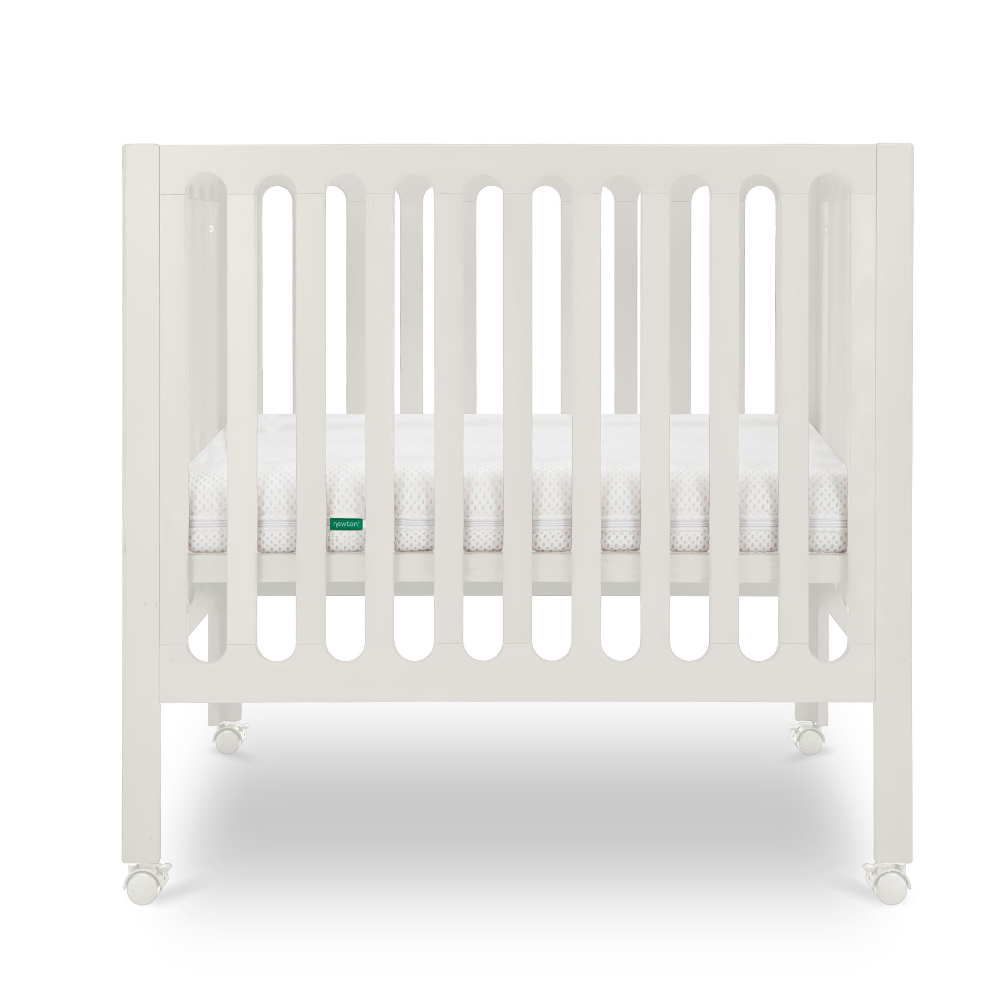 Warm White modern baby crib with a thin mattress on wheels.