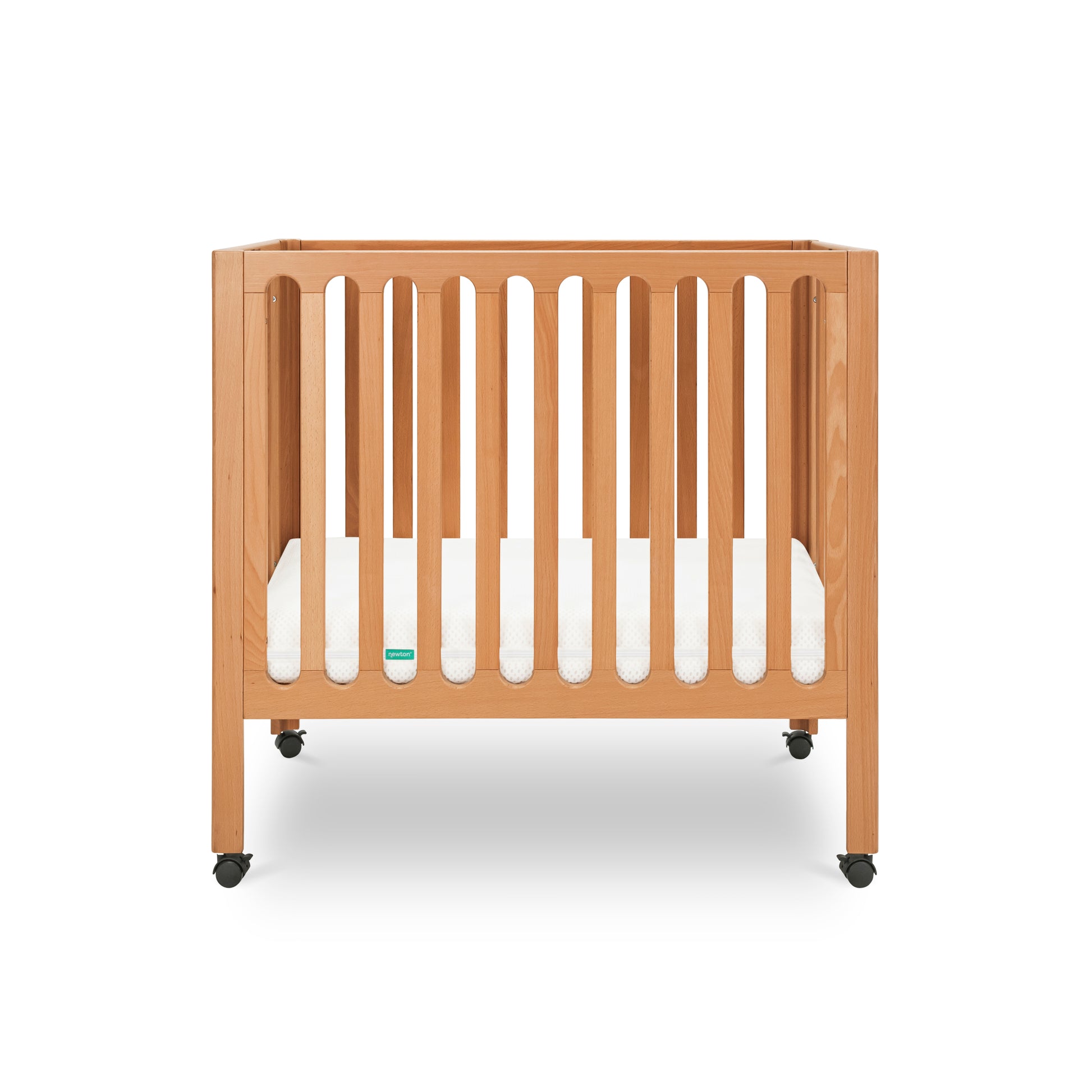 Modern wooden crib on wheels with visible mattress, isolated on a white background. 