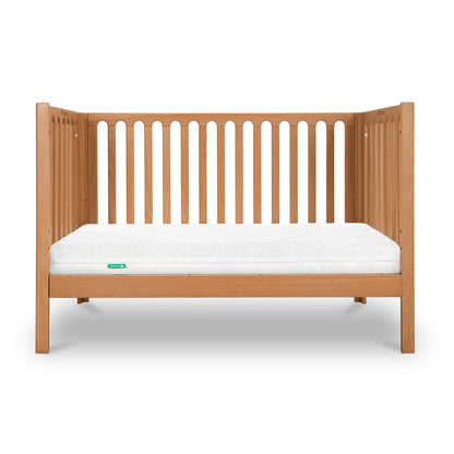 A wooden baby crib with a white Newton baby mattress.