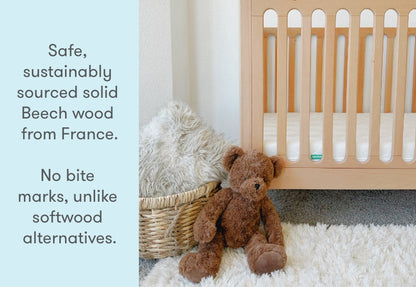 newton galileo crib in natural color in a nursery with stuffed animals, text reads "safe, sustainably sourced solid beech wood from France. No bite marks, unlike softwood alternatives.