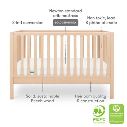Front view of the Newton Galileo Convertible Crib by Newton Baby in solid beech wood, showing labeled features: 3-in-1 convertible design, heirloom quality, non-toxic materials, toddler bed option, and certification badges at bottom right.