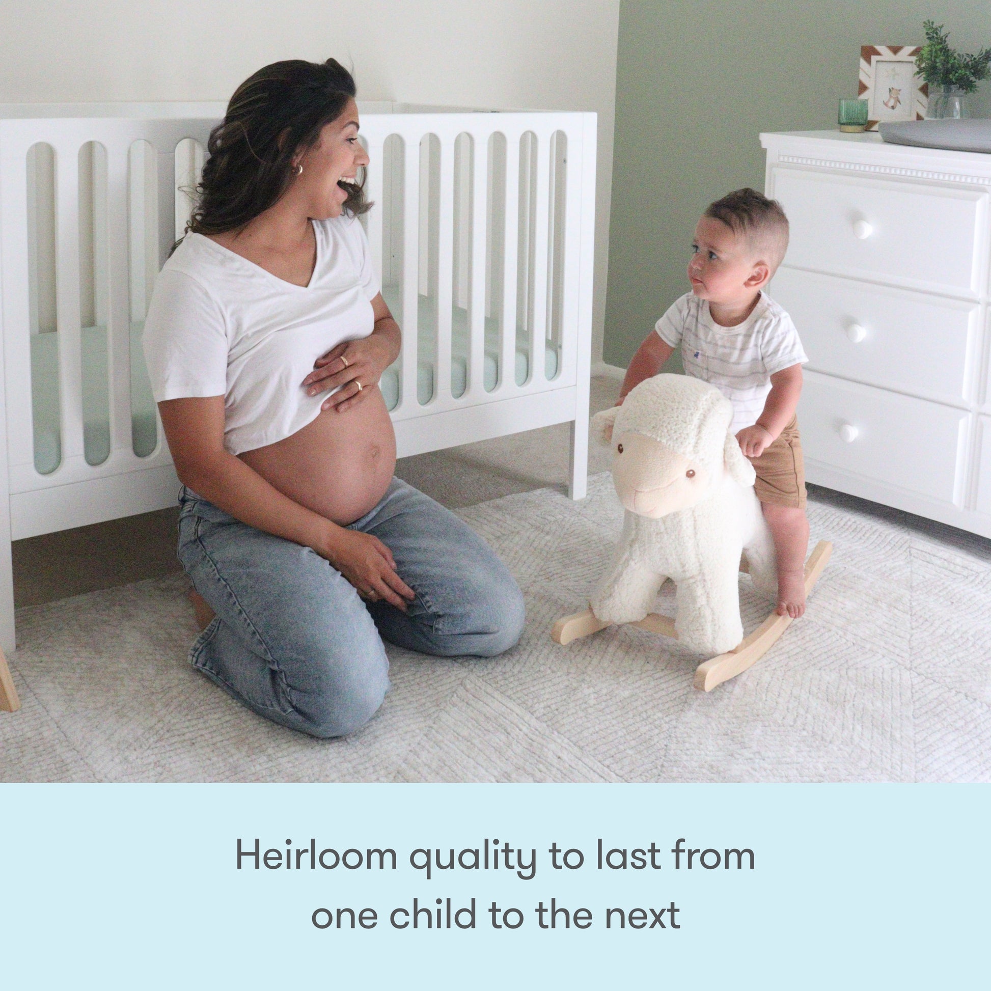 A pregnant woman smiles at a toddler riding a plush rocking sheep in a nursery with the Newton Galileo Convertible Crib by Newton Baby, dresser, and soft decor creating a calm, cozy space. Text: “Heirloom quality to last from one child to the next.”.