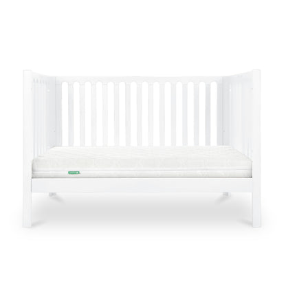 The Newton Galileo Convertible Crib by Newton Baby features white beech wood, vertical slats, and a white mattress. Shown on a plain white background, this crib easily converts to a toddler bed as your child grows.