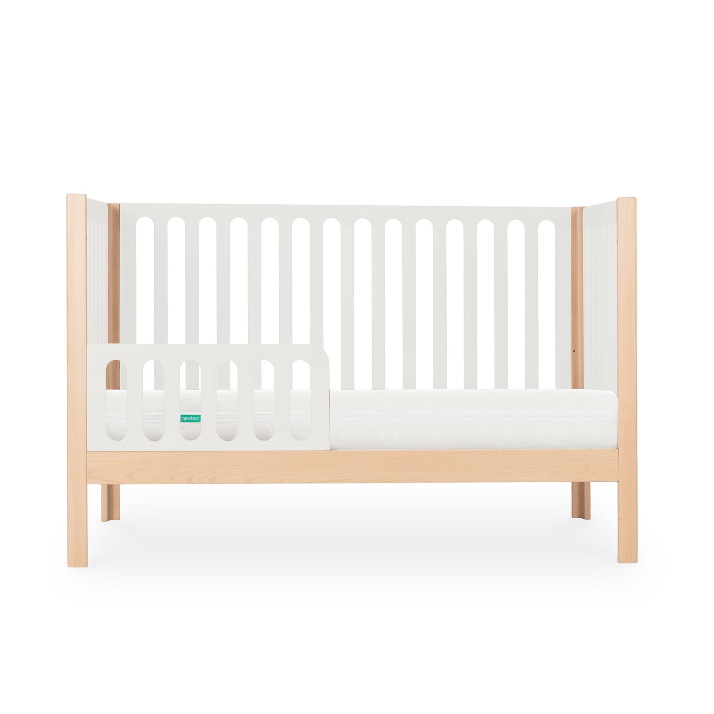 The Newton Galileo Convertible Crib by Newton Baby features a modern beech wood frame with light wooden legs, white slatted sides, and a partial guard rail; it easily converts to a toddler bed for long-term versatility. Photographed against a white background.