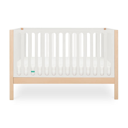 The Newton Baby Newton Galileo Convertible Crib features natural beech wood legs, a white frame with slatted sides, and a white mattress. This modern crib converts to a toddler bed for lasting versatility and is pictured against a plain white background.