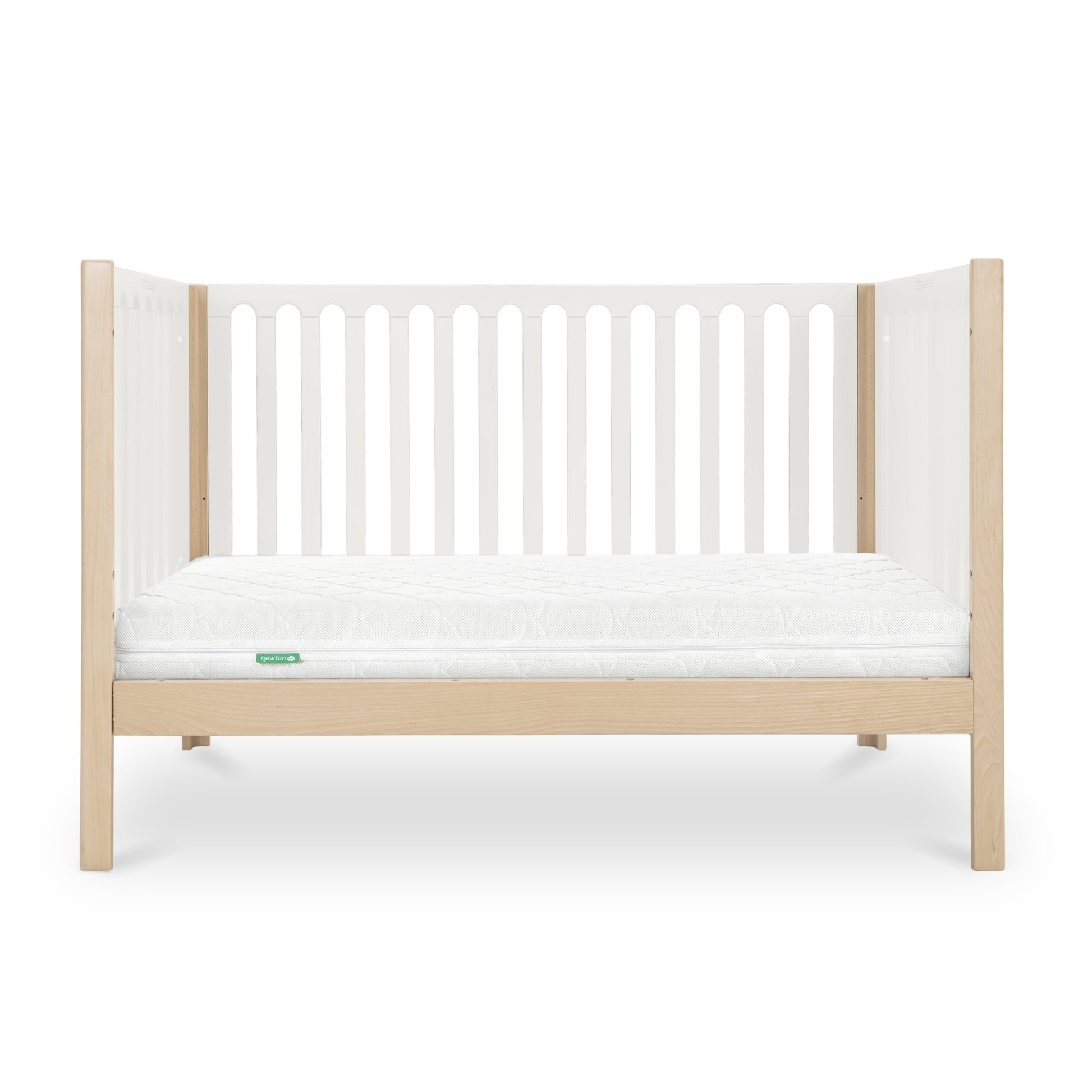 The Newton Galileo Convertible Crib by Newton Baby features a modern beech wood frame with light wood legs, white slatted sides, and a white mattress. Shown from the front on a white background. Converts to a toddler bed for added versatility.