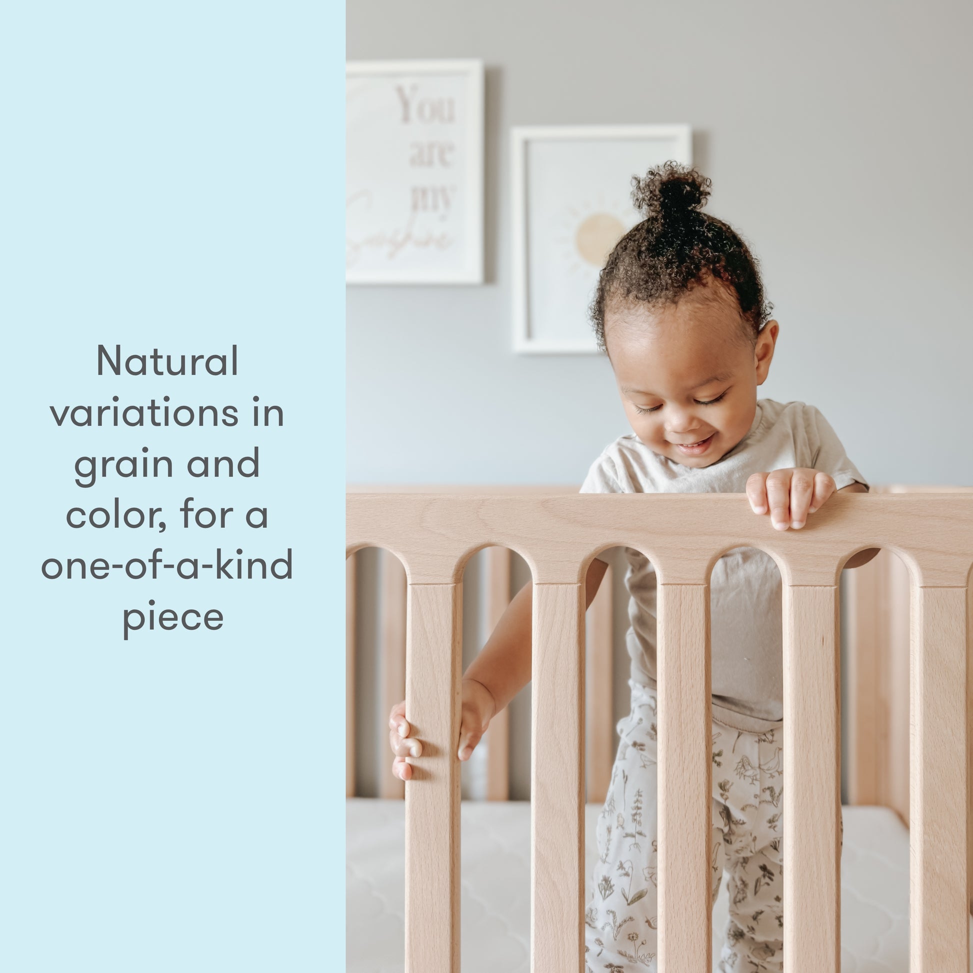 toddler standing up in newton galileo crib in natural color, text reads "natural variations in grain nd color, for a one-of-a-kind piece"