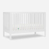 The Newton Galileo Convertible Crib by Newton Baby features vertical slats on all sides, modern beech wood construction, includes a mattress, and easily converts to a toddler bed for long-lasting use.