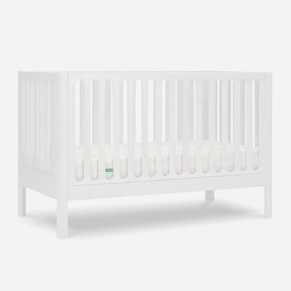 The Newton Galileo Convertible Crib by Newton Baby features vertical slats on all sides, modern beech wood construction, includes a mattress, and easily converts to a toddler bed for long-lasting use.
