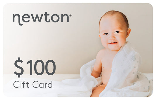 Happy baby wrapped in a light cloth displays a Newton $100 Gift Card. GIFT100