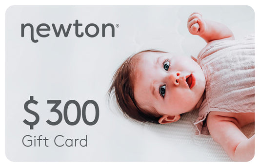 Adorable baby lying down with a text "Newton $300 Gift Card" above the image. GIFT300