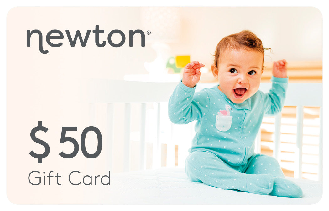 Excited baby sitting in a crib wearing a blue bodysuit, paired with a Newton $50 Gift Card promotion. GIFT50