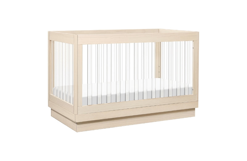 Modern light wood baby crib with white mattress visible through vertical slats, isolated on a white background. 999-8500-WNA