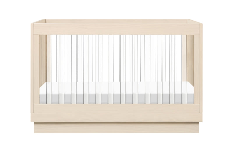 Modern wooden baby crib with a white mattress, isolated on a white background.